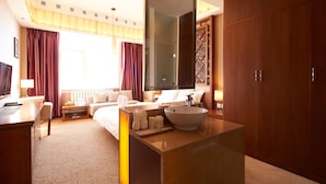 A hotel room with a bed, bedside table, lamp, and a large mirror. - Floral Hotel Shangri-la Budange (Deqin)