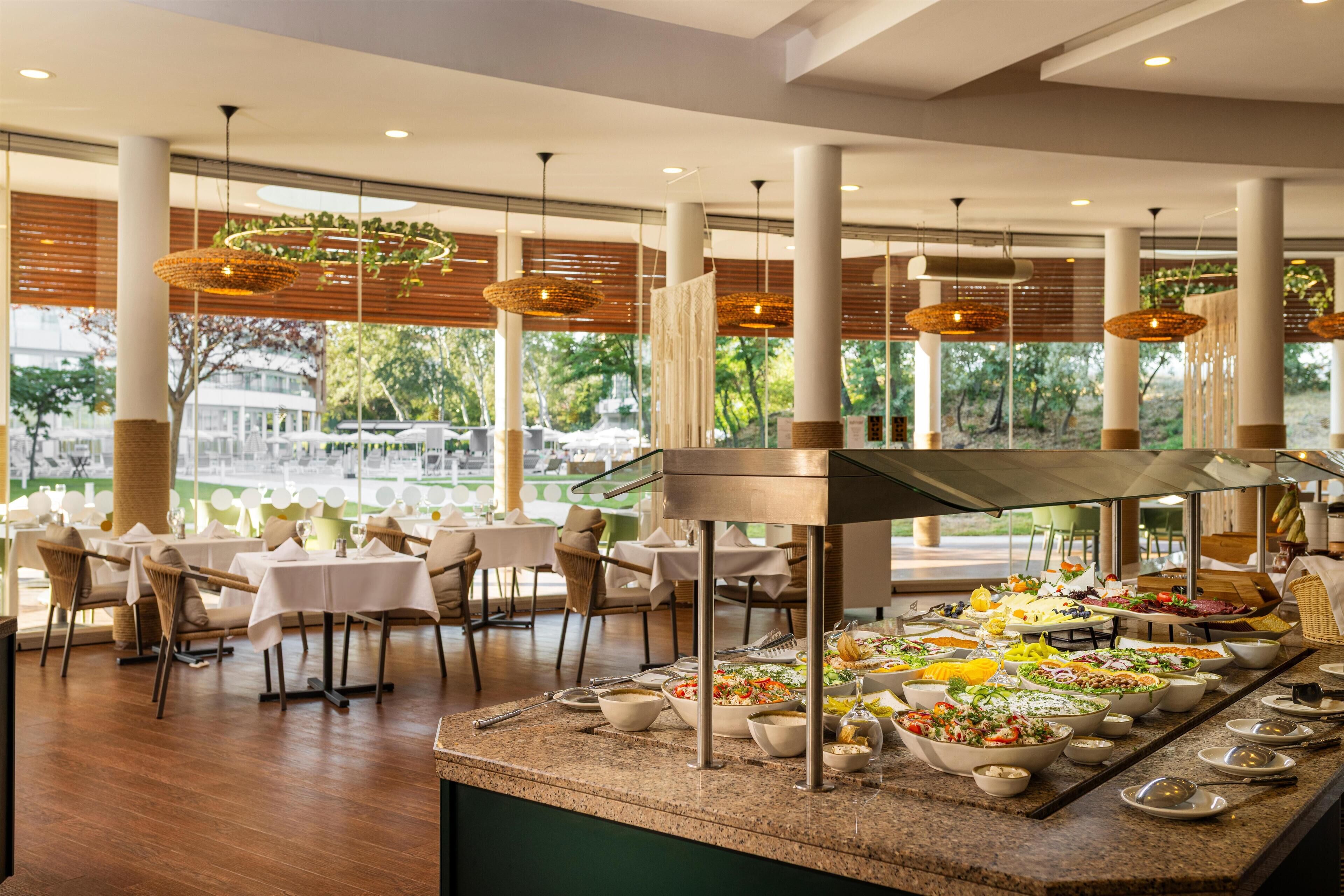 A buffet setup with various food items and a seating area with tables and chairs.