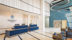 A modern reception area with a blue and white color scheme, featuring a reception desk, seating area, and a logo for 'ALUASOUL Sunny Beach'. - AluaSoul Sunny Beach - All Inclusive – Adults Only  (Sunny Beach)