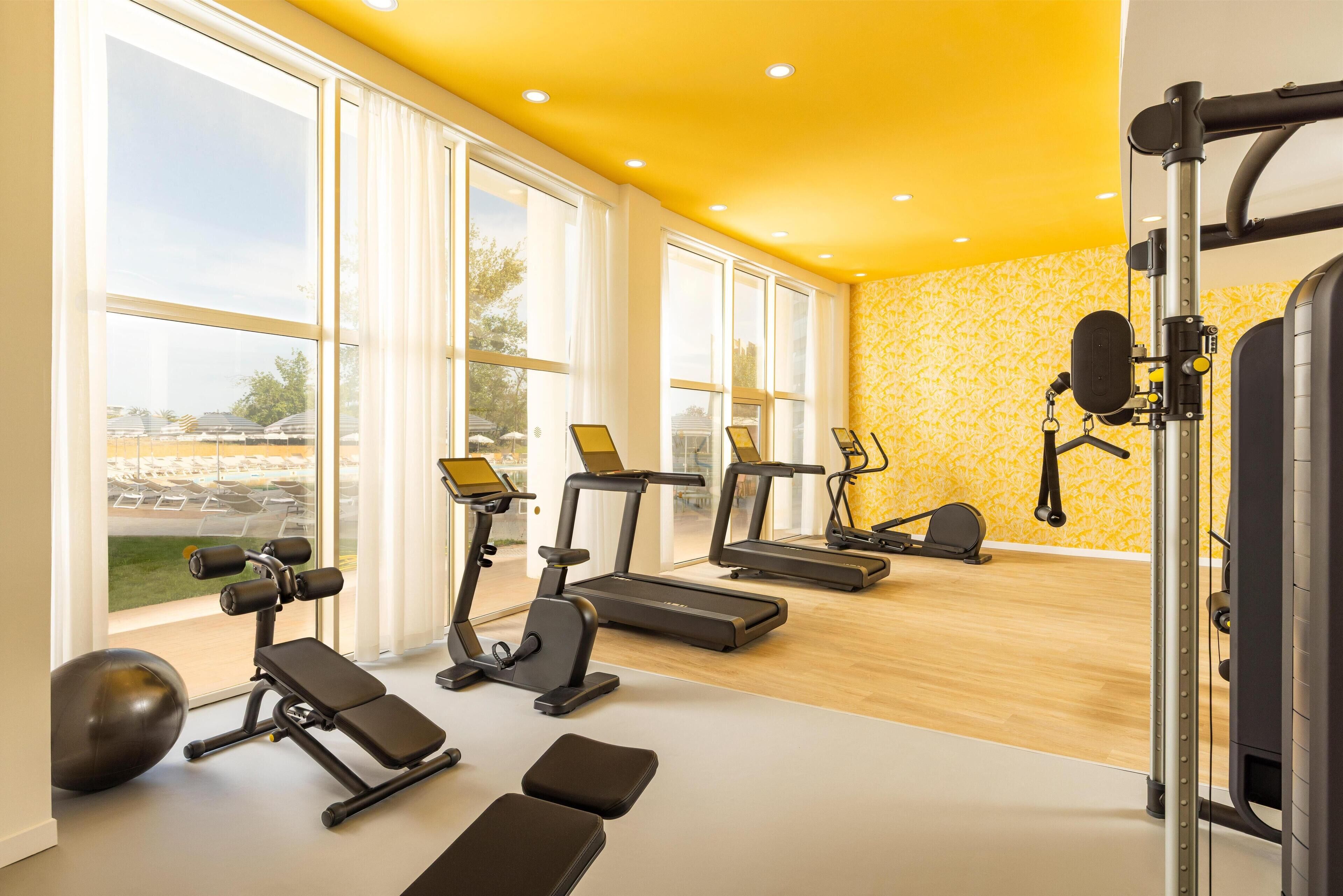 A gym with treadmills, elliptical machines, and weightlifting equipment.