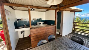 A compact kitchen with a microwave, sink, and wooden counter. - Bubble Dome Village- Glamping (Saint-Joseph)