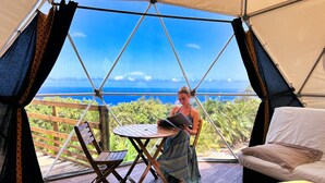 A tent with a wooden deck, a table, and a bed. - Bubble Dome Village- Glamping (Saint-Joseph)