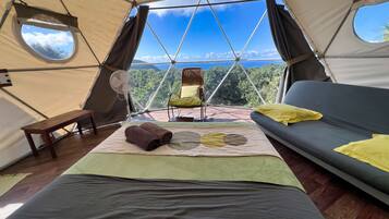 Una carpa con una cama, una silla y vistas al exterior.