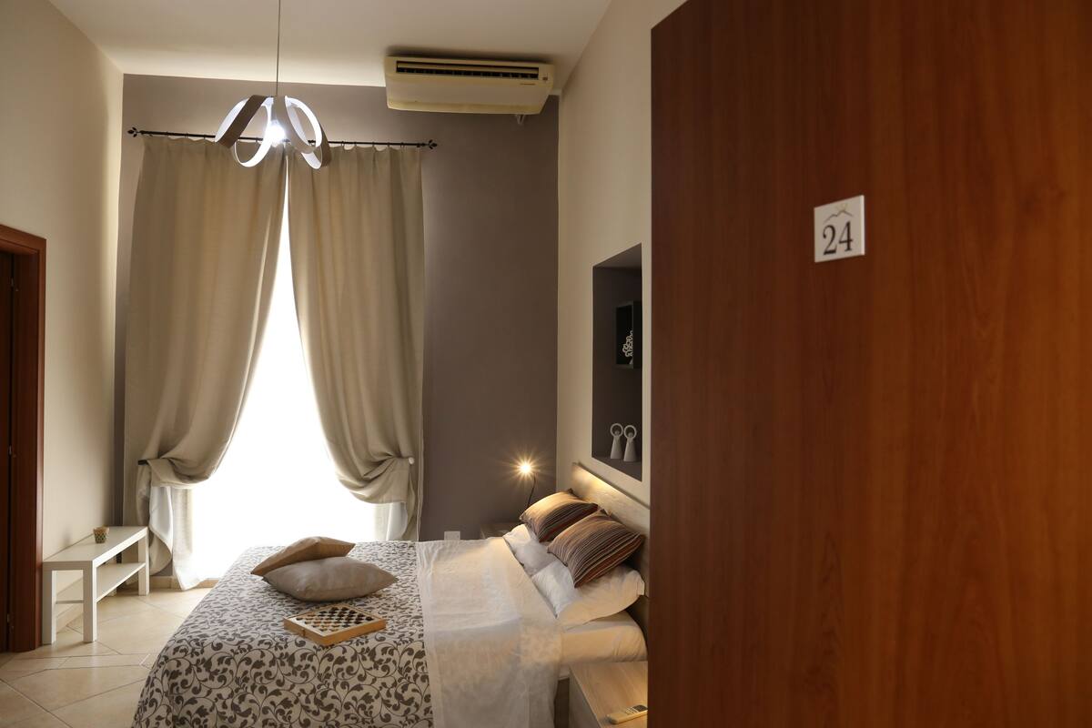Ein Schlafzimmer mit einem Bett, einem Nachttisch, einem Spiegel und einer Beschilderung.