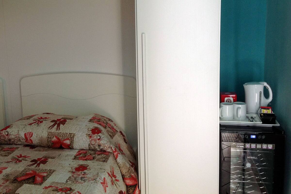 Ein Schlafzimmer mit einem Bett, einem Nachttisch und einer Kaffeemaschine.