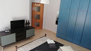 A bedroom with a bed, a TV, a wardrobe, and a door with a sign. - Salamina's Apartment (Salamis)