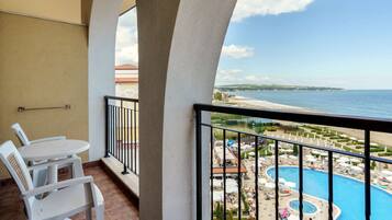 Ein Balkon mit Blick auf ein Schwimmbecken und einen Strand.