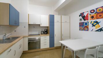 Appartamento Deluxe, vista città | Cucina privata | Frigorifero con congelatore, microonde, forno, piano cottura
