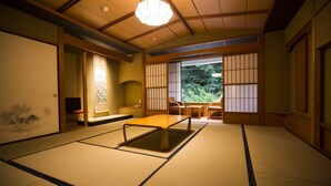 Une pièce de style japonais traditionnel, avec un sol recouvert de tatamis, une table basse et des portes coulissantes.