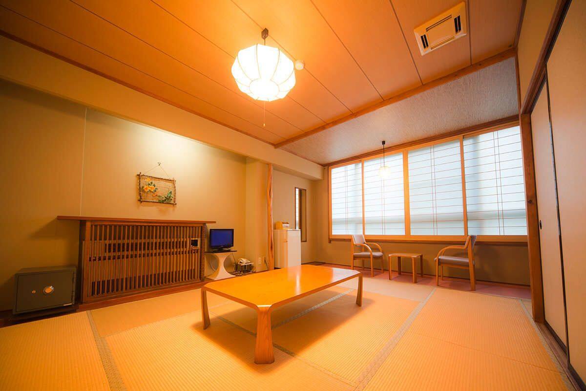Une pièce de style japonais traditionnel, avec un sol recouvert de tatamis, une table basse et des portes coulissantes.