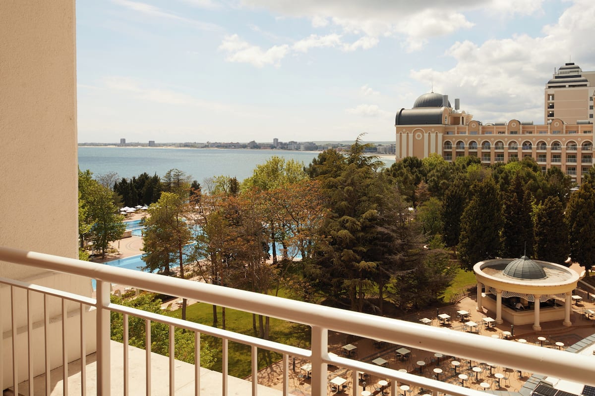 Een hotel met een zwembad, terras en uitzicht op het water.