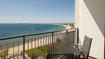 En balkon med udsigt over en strand og ocean.