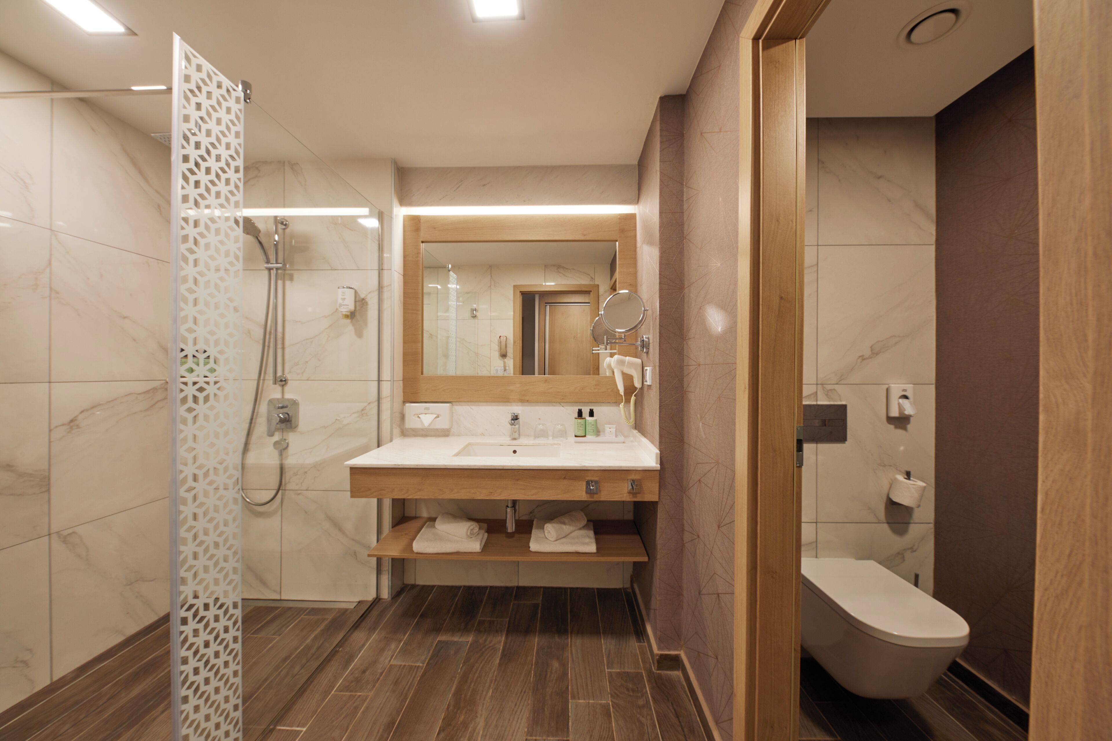 Un bagno moderno con doccia, lavandino e WC.