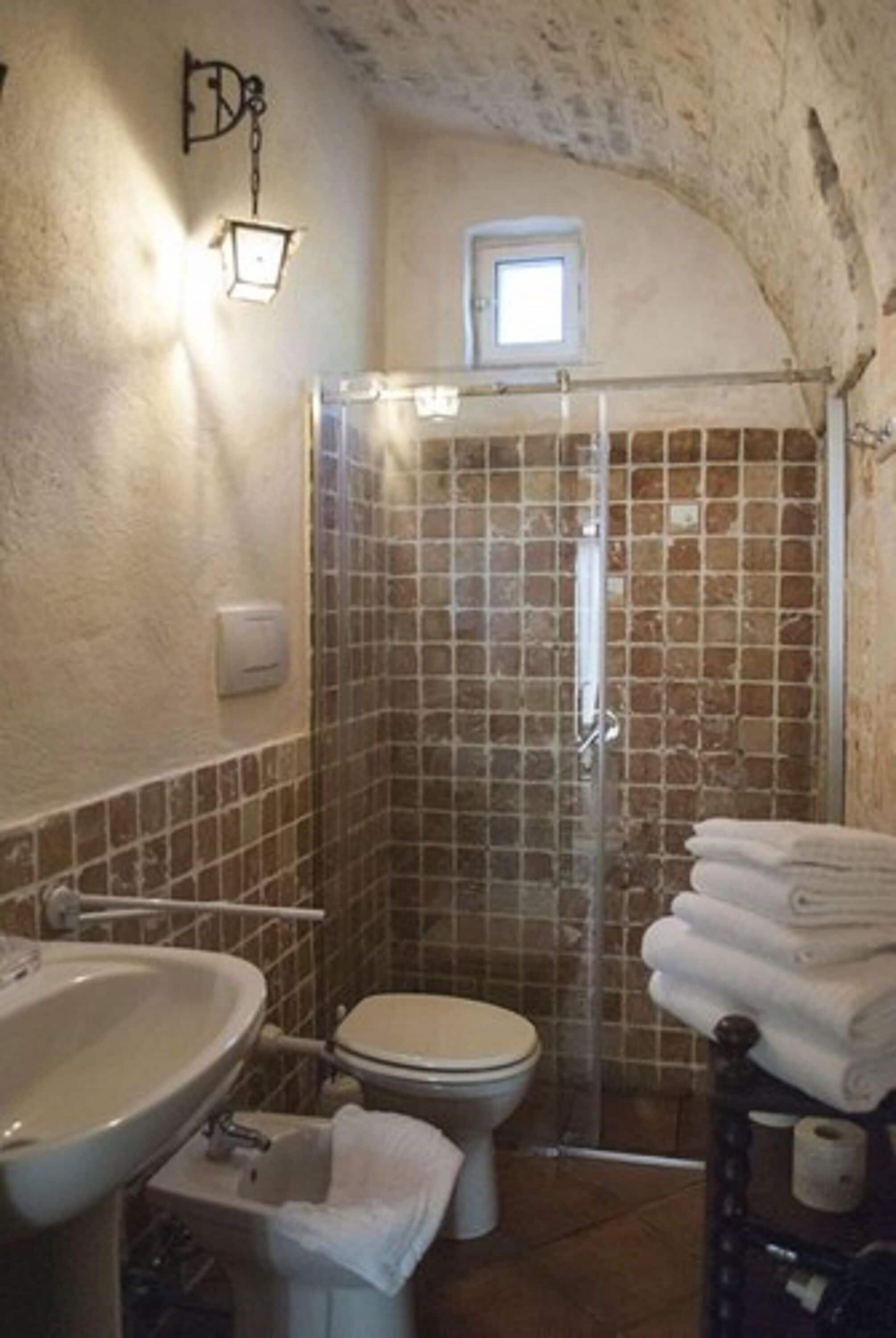 A bathroom with a shower, toilet, and sink.