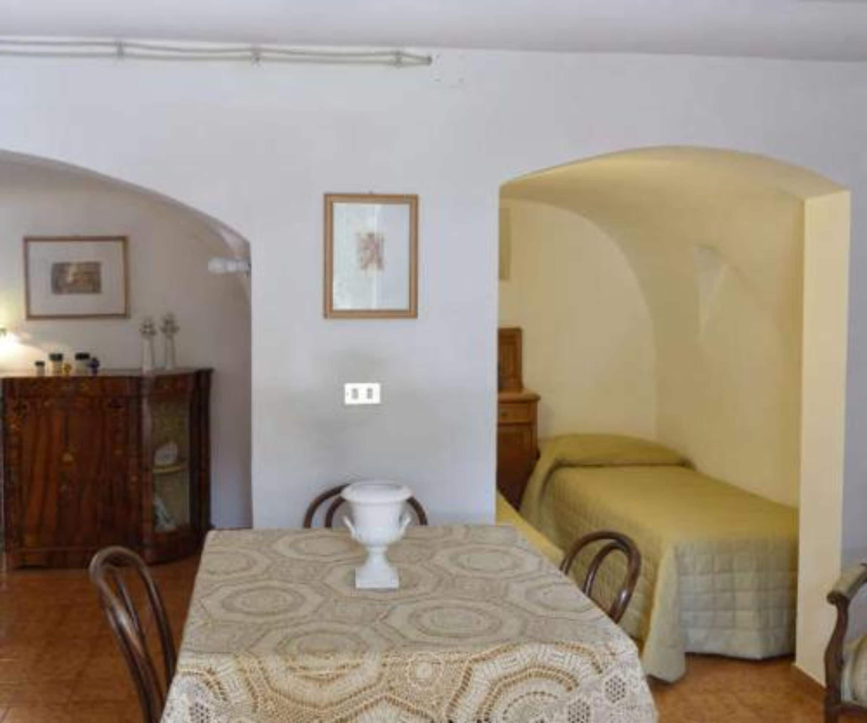 Una habitación con una mesa de comedor, sillas, una cama y un armario.