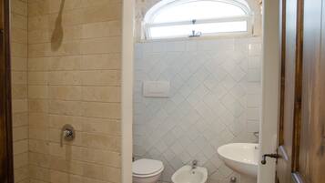 Un baño con ducha, inodoro y bidé.