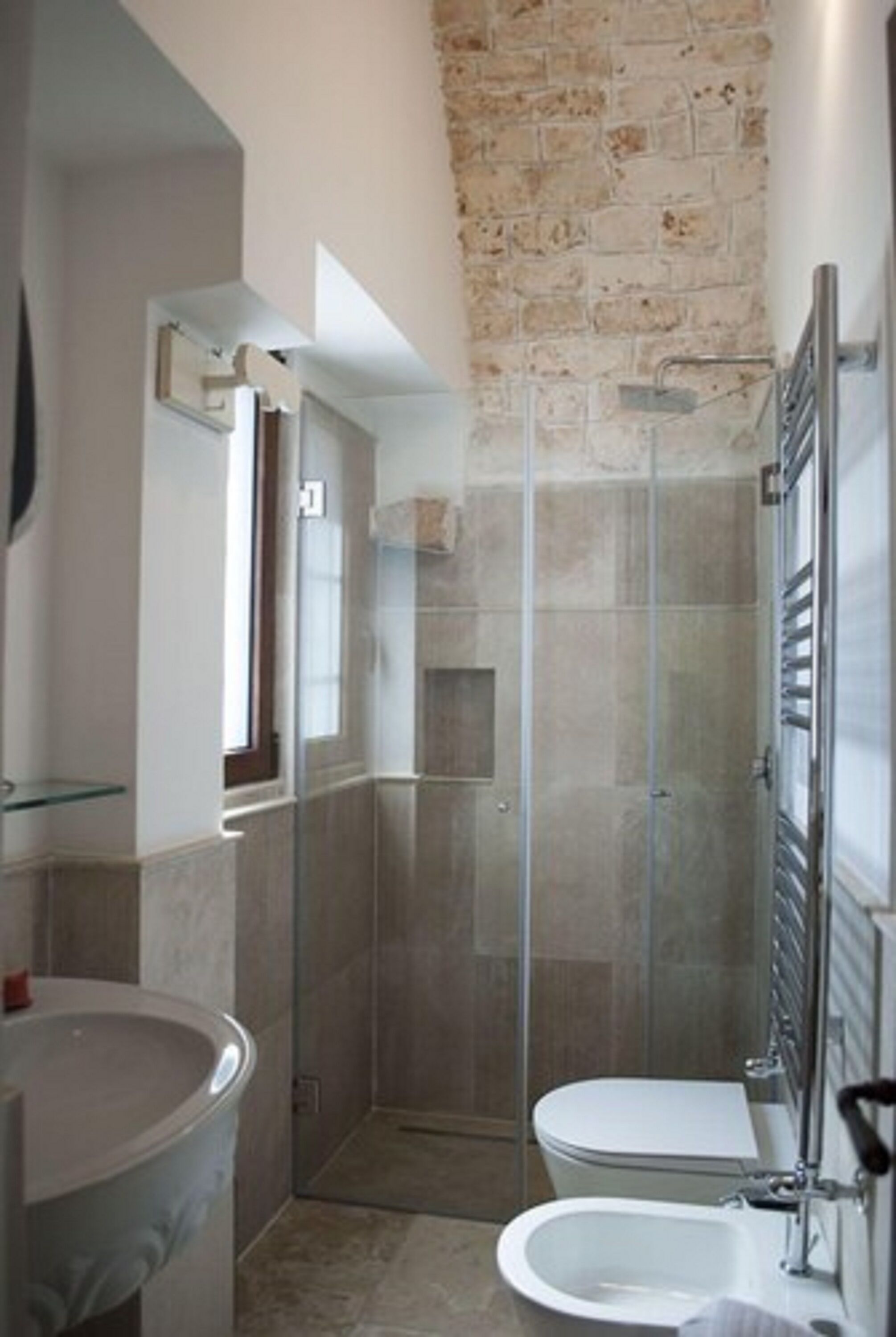 Un baño con ducha envuelta en vidrio, inodoro y lavamanos.