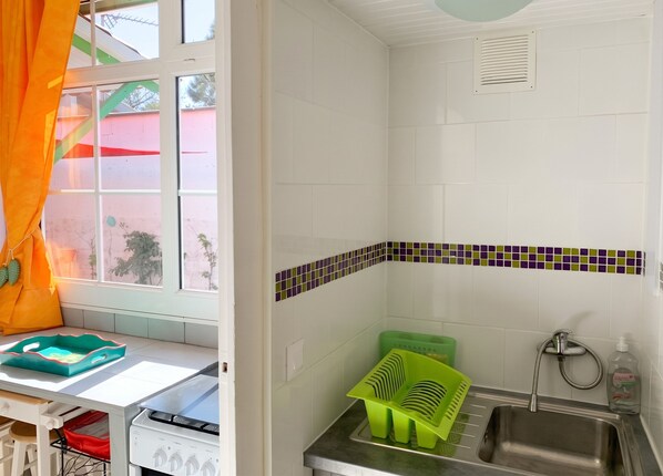 A kitchen with a window, a sink, and a stove. - Homerez - Charming House Soulac-sur-Mer, Garden, 65 m² (Soulac-sur-Mer)
