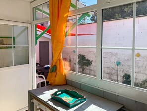A room with a window, a table with a tray, and a chair. - Homerez - Charming House Soulac-sur-Mer, Garden, 65 m² (Soulac-sur-Mer)