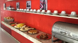 A buffet setup with various food items and a beverage dispenser. - Pousada Praia de Guarajuba (Camaçari)