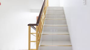 A staircase with white steps and a yellow handrail. - OYO 152 Sangco Condotel (Manila)