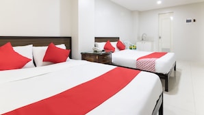A hotel room with two beds, each with red and white bedding, a small bedside table with a telephone, and a white door. - OYO 152 Sangco Condotel (Manila)