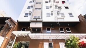 A multi-story building with numbered windows and air conditioning units. - OYO 152 Sangco Condotel (Manila)
