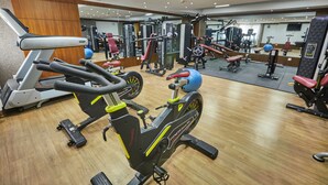 A gym with various exercise equipment, including treadmills, stationary bikes, and weight machines.
