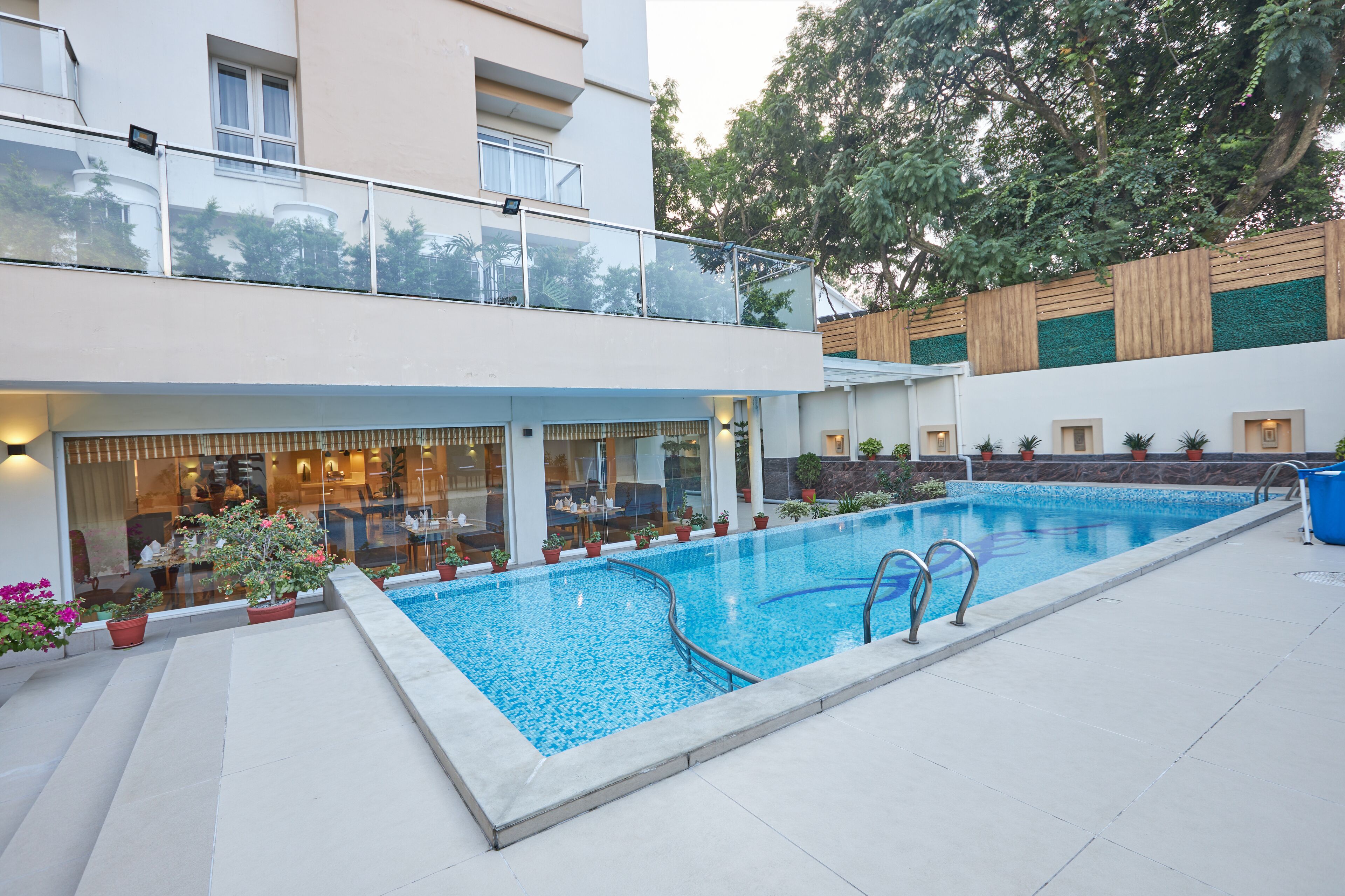 Una piscina al aire libre, sombrillas, sillones reclinables de piscina