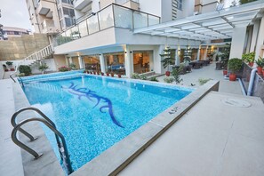 Piscine extérieure, parasols de plage, chaises longues