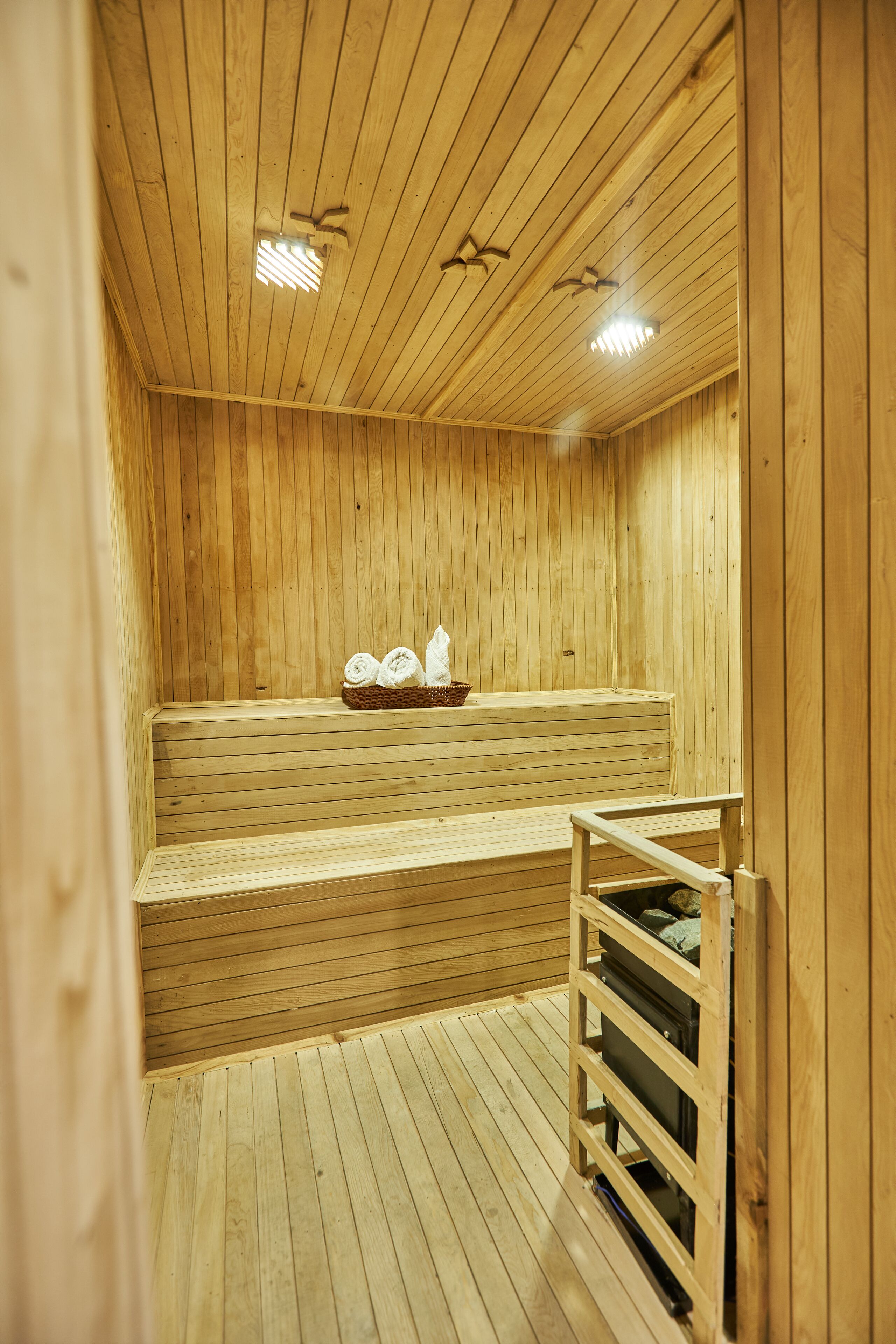 Un sauna en bois, doté de bancs et d’une étagère pour ranger les serviettes.