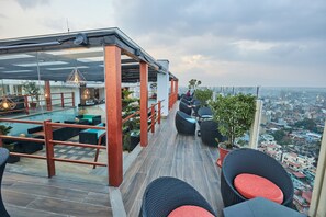 A rooftop terrace with outdoor seating, a pool, and a city view. - Hotel Crowne Imperial - Kathmandu (Kathmandu)