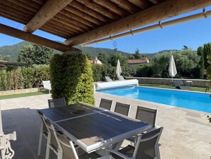 A covered outdoor area with a pool, seating, and a view of the mountains. - Detached Villa with Private Pool, Air-Conditioned (La Môle)