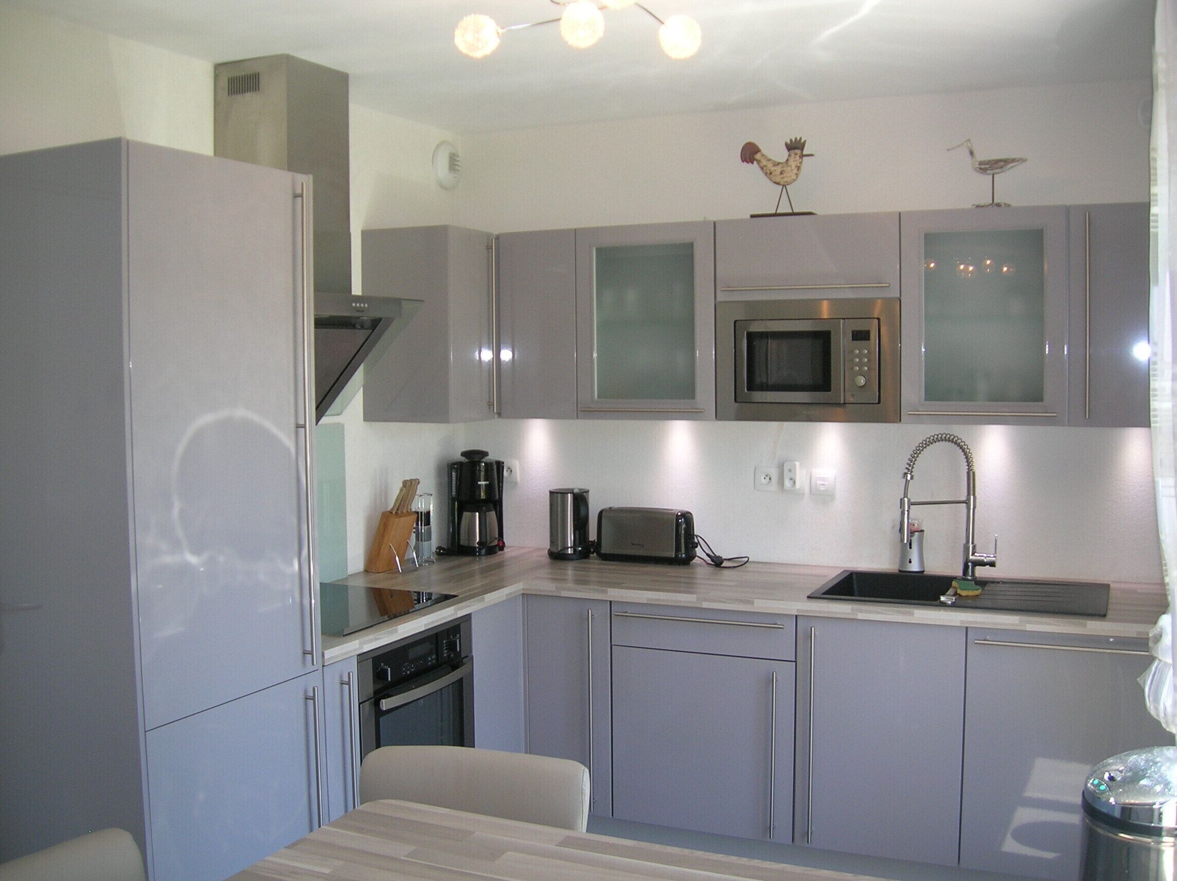 A modern kitchen with grey cabinets, a microwave, a toaster, and a sink.
