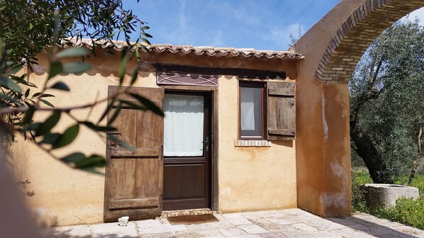 A rustic building with a tiled roof, a wooden door, and a window with shutters. - La Torre Rossa (Itri)