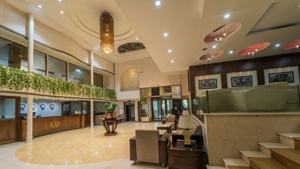 A spacious lobby with a reception desk, seating area, and a staircase. - Hotel Celebration - Raipur (Raipur)