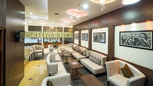 A modern lobby with sofas, tables, and artwork on the walls. - Hotel Celebration - Raipur (Raipur)