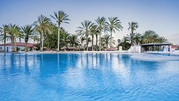 Een buitenzwembad, ligstoelen bij het zwembad