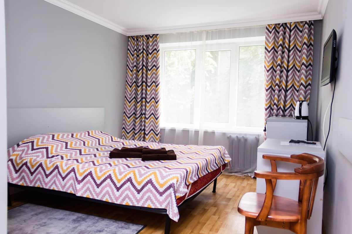 Un dormitorio con cama, escritorio y silla.