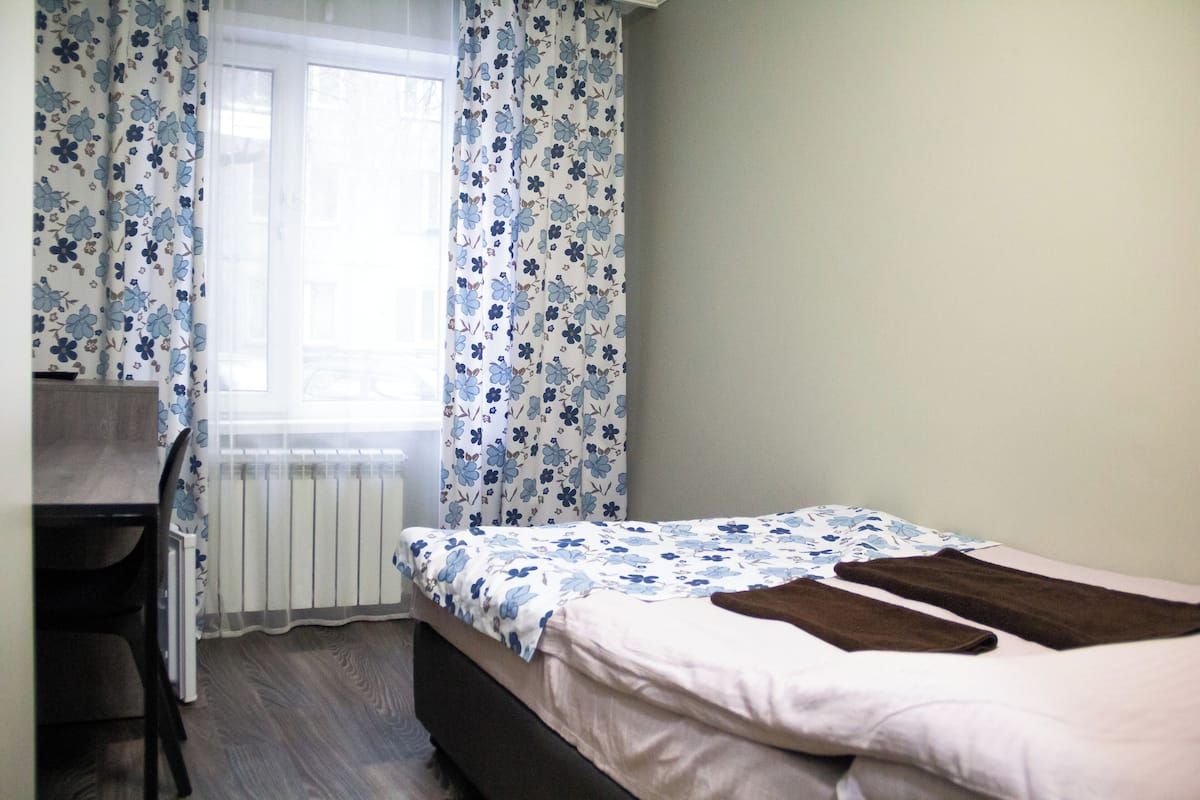 Un dormitorio con una cama, un escritorio y una silla.