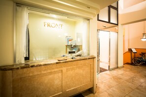 A reception area with a counter, a glass door labeled "FRONT", and a bicycle to the right. - Hotel Shonan Bay - Adults Only (Chigasaki)