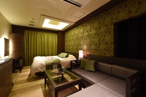 Ein Hotelzimmer mit einem Bett, einer Couch, einem Glastisch, einem Schreibtisch und einer Lampe.