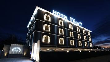 Un edificio de hotel de varios pisos con un cartel llamativo que dice "HOTEL Dior 7".