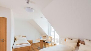 A bedroom with two beds, a desk, and a chair. - Gästehaus Neubauer (Althegnenberg)