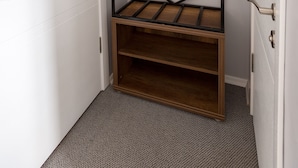 A corner room with a built-in wardrobe, a wooden bench, and a coat rack. - Baskent Konukevi (Ankara)