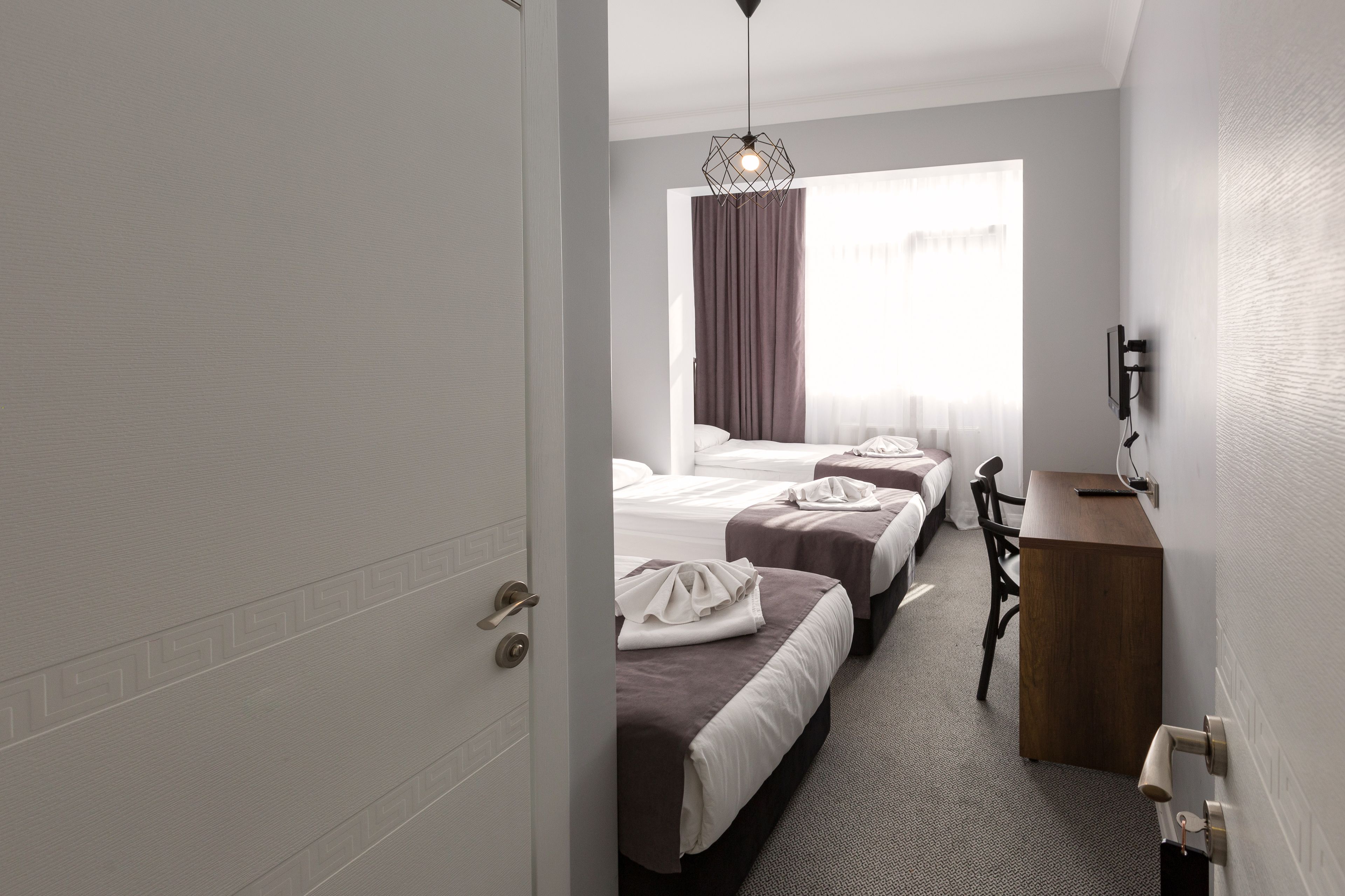 Une chambre d’hôtel avec deux lits, un bureau et une chaise.