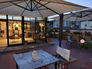 An outdoor patio area with a table and chairs, a lantern, and potted plants. - Spanish Palace Rooms, Apartment & Terrace (Naples)
