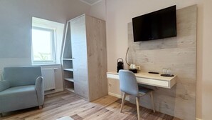 Habitación moderna con escritorio, silla y televisor montado.