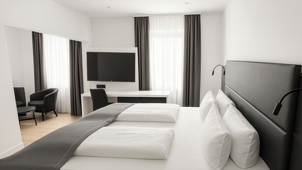 Una habitación de hotel moderna con una cama grande, un escritorio, una silla y un televisor.