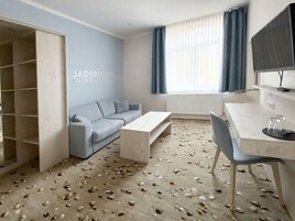 Una habitación moderna con un sofá, una mesa de centro, un escritorio y un televisor.
